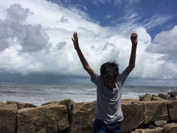 Woman standing by sea against sky