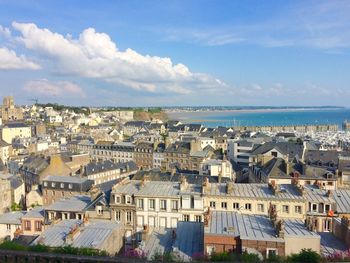 High angle view of townscape by sea against sky