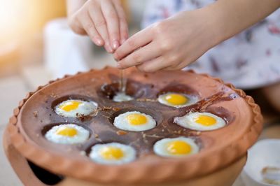 Child hand hammering quail eggs into the pan. quail egg mortar, thai food