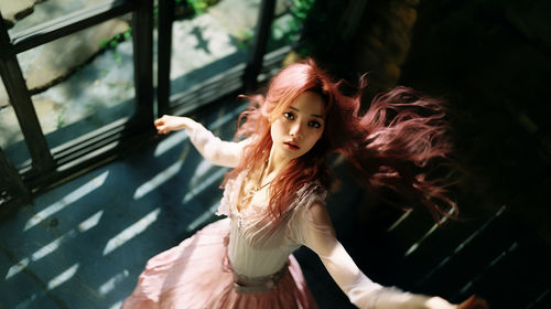 Side view of young woman looking through window