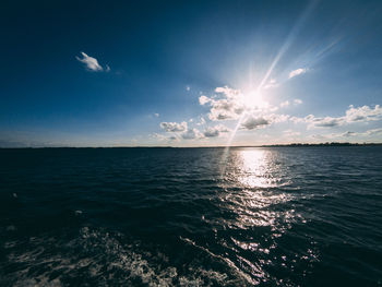 Scenic view of sea against bright sun