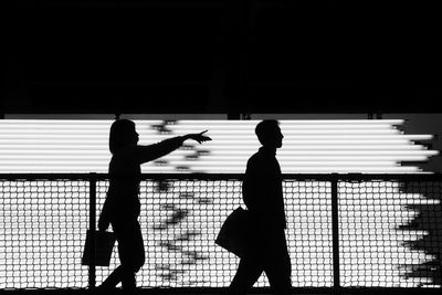 Silhouette people walking on street at night