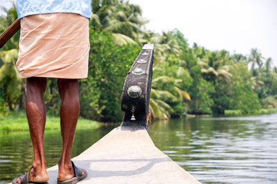 Low section of man standing by lake