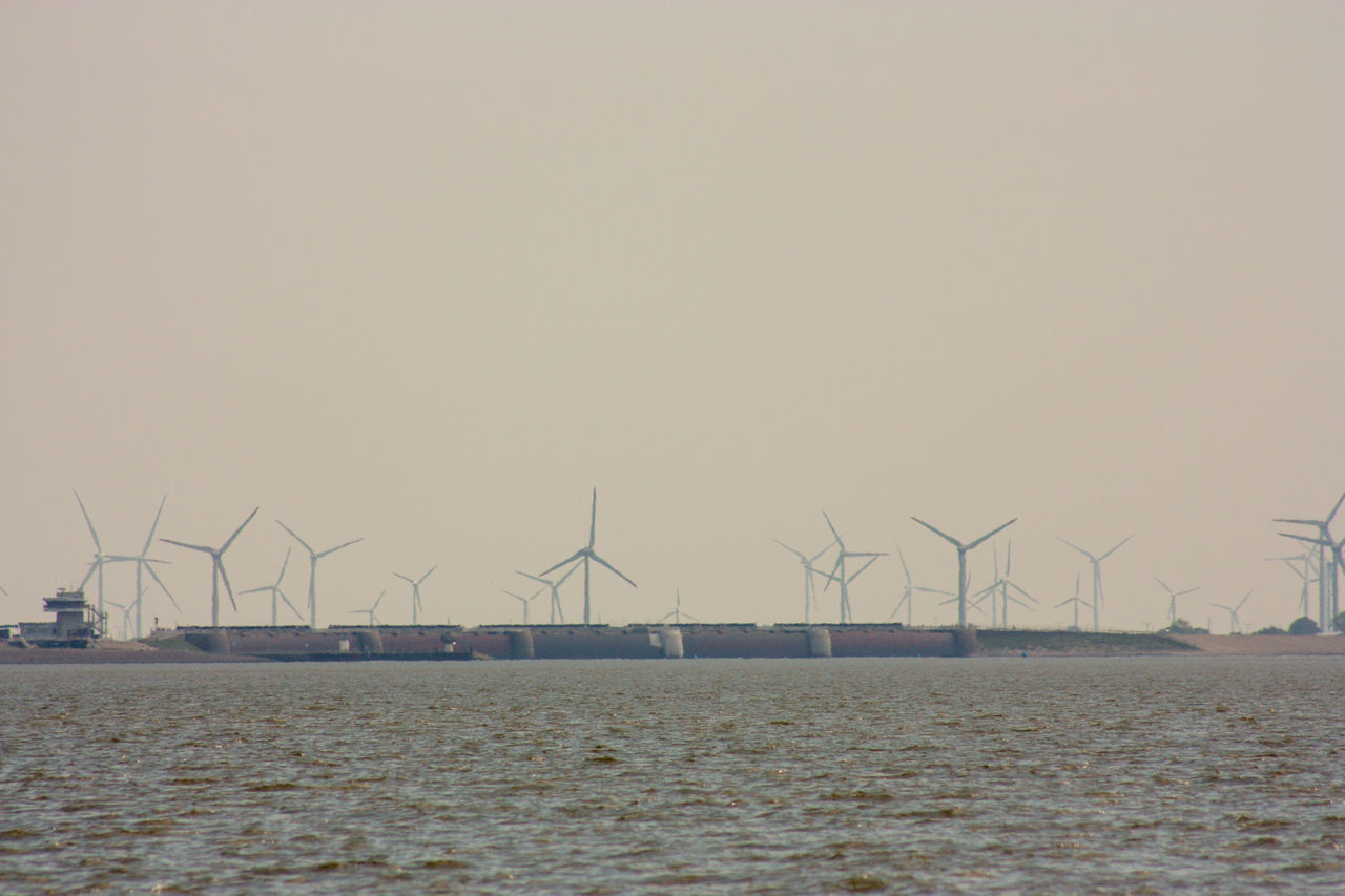 CRANES IN WATER AGAINST SKY