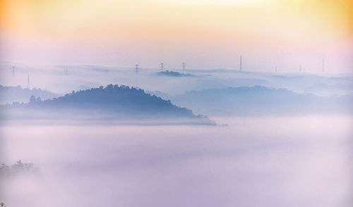 Scenic view of fog against sky during sunset