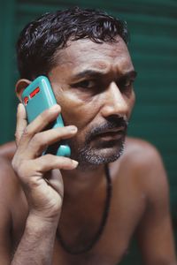 Close-up portrait of young man using mobile phone