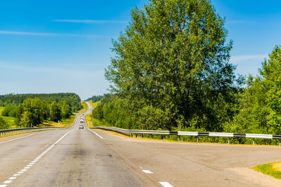 Road amidst trees against sky