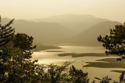 Scenic view of lake by mountains against sky