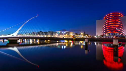 Illuminated bridge over river at night