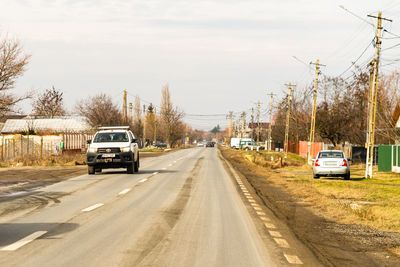 Cars on road against sky in city