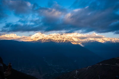 Scenic view of snowcapped mountains against sky during sunset