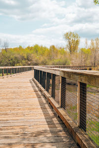 Footbridge over footpath against sky