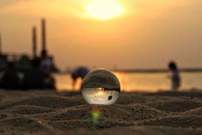 Close-up of water on beach against sky during sunset