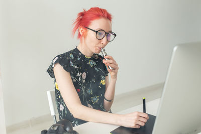 Woman smoking vape while working at home