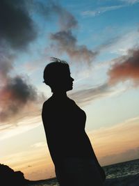 Silhouette woman standing against sky during sunset