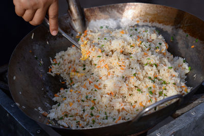 Midsection of person preparing food in pan