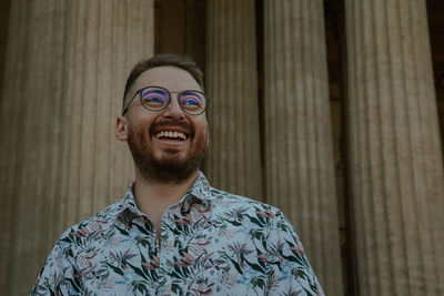 Portrait of young man standing against wall