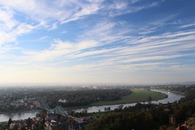 High angle view of city by river against sky