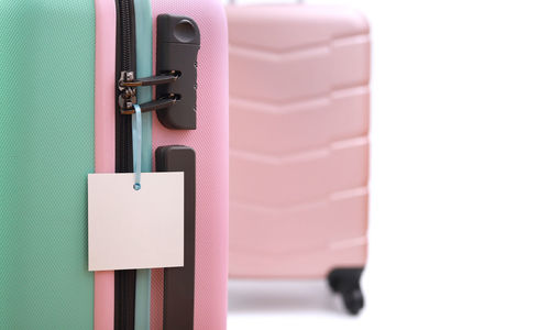Close-up of wheeled luggage against white background