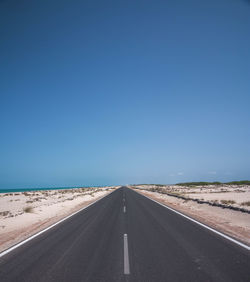 Road against clear blue sky