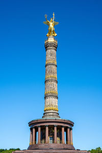 Low angle view of statue against blue sky