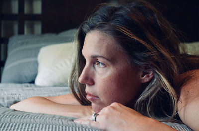 Portrait of beautiful woman lying down on a bed.