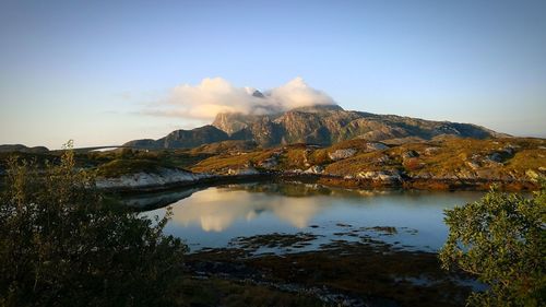 Scenic view of lake by mountain against sky