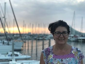 Portrait of mature woman at harbor against sky in la grande-motte during sunset