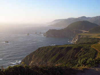 Scenic view of sea and mountains against clear sky