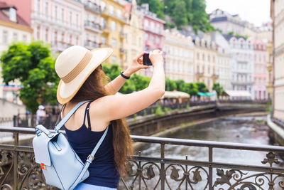 Man photographing with mobile phone in city