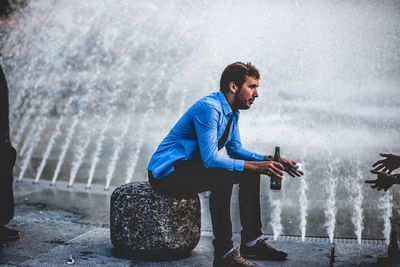 Side view of young man looking at water