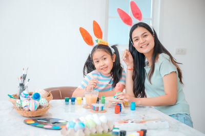 Portrait of happy girl and son on table