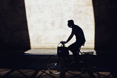 Side view of man riding bicycle on street
