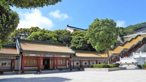 Panoramic view of building and trees against sky