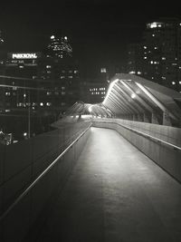Illuminated walkway in city at night