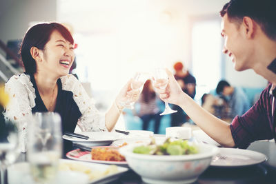 Couple toasting drinks at table in restaurant