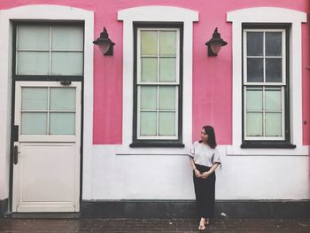 Full length of woman standing against building