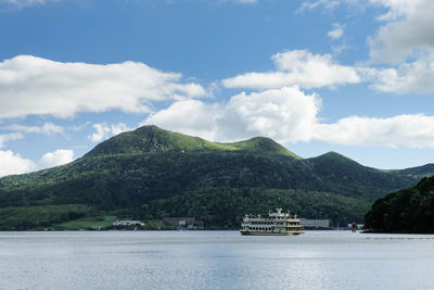 Scenic view of sea by mountains against sky