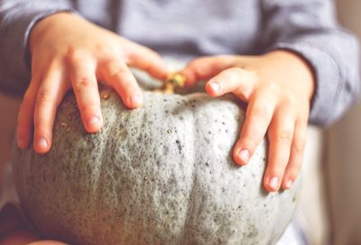 Midsection of woman holding pumpkin