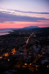 High angle view of illuminated city against sky at sunset