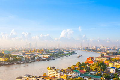 High angle view of city by sea against sky