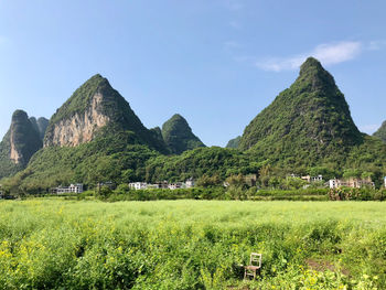 Panoramic view of mountain range and field against sky