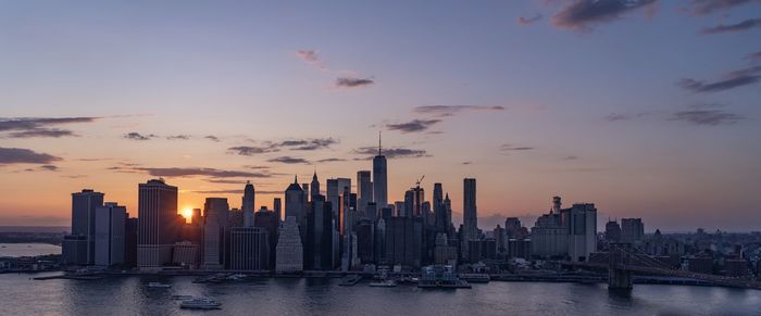 View of buildings at waterfront during sunset