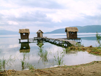 Built structure by lake against sky