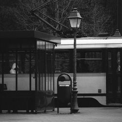 Illuminated street light by building in city