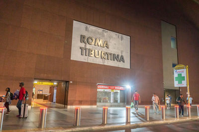 People walking on illuminated city at night