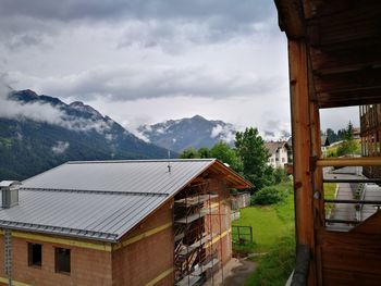 Houses by buildings against sky