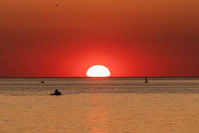 Scenic view of sea against orange sky