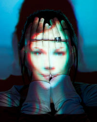 Close-up of woman covering face with light