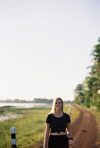 Portrait of woman standing on land against clear sky